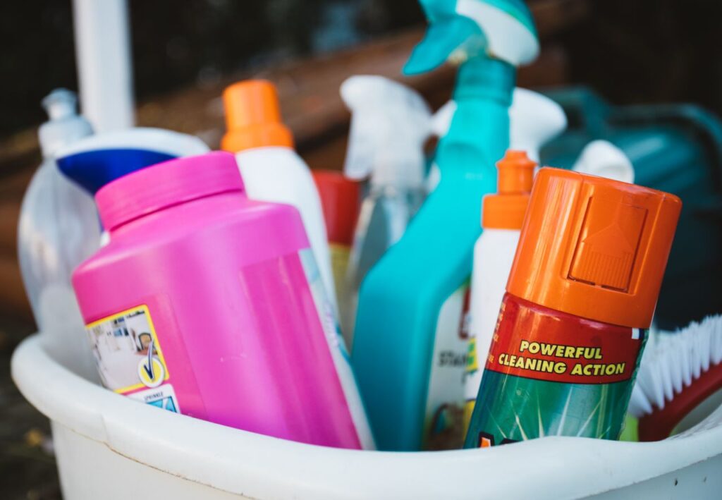 Mastering the First Impression: Your intriguing post title goes here Close-up of assorted cleaning supplies in a bucket outdoors, showcasing various detergents and sprays.